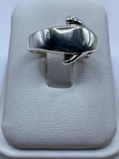 Anillo de plata con forma de pájaro minimalista en la mano de una mujer