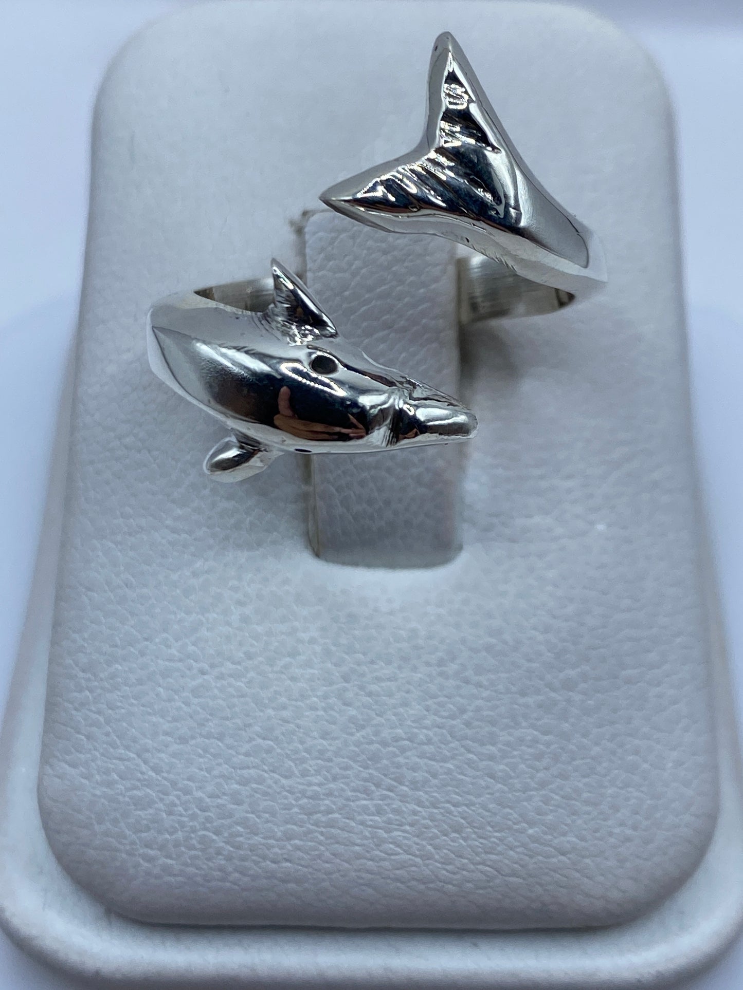 Anillo ajustable de plata con tiburones enfrentados, vista superior en estuche blanco
