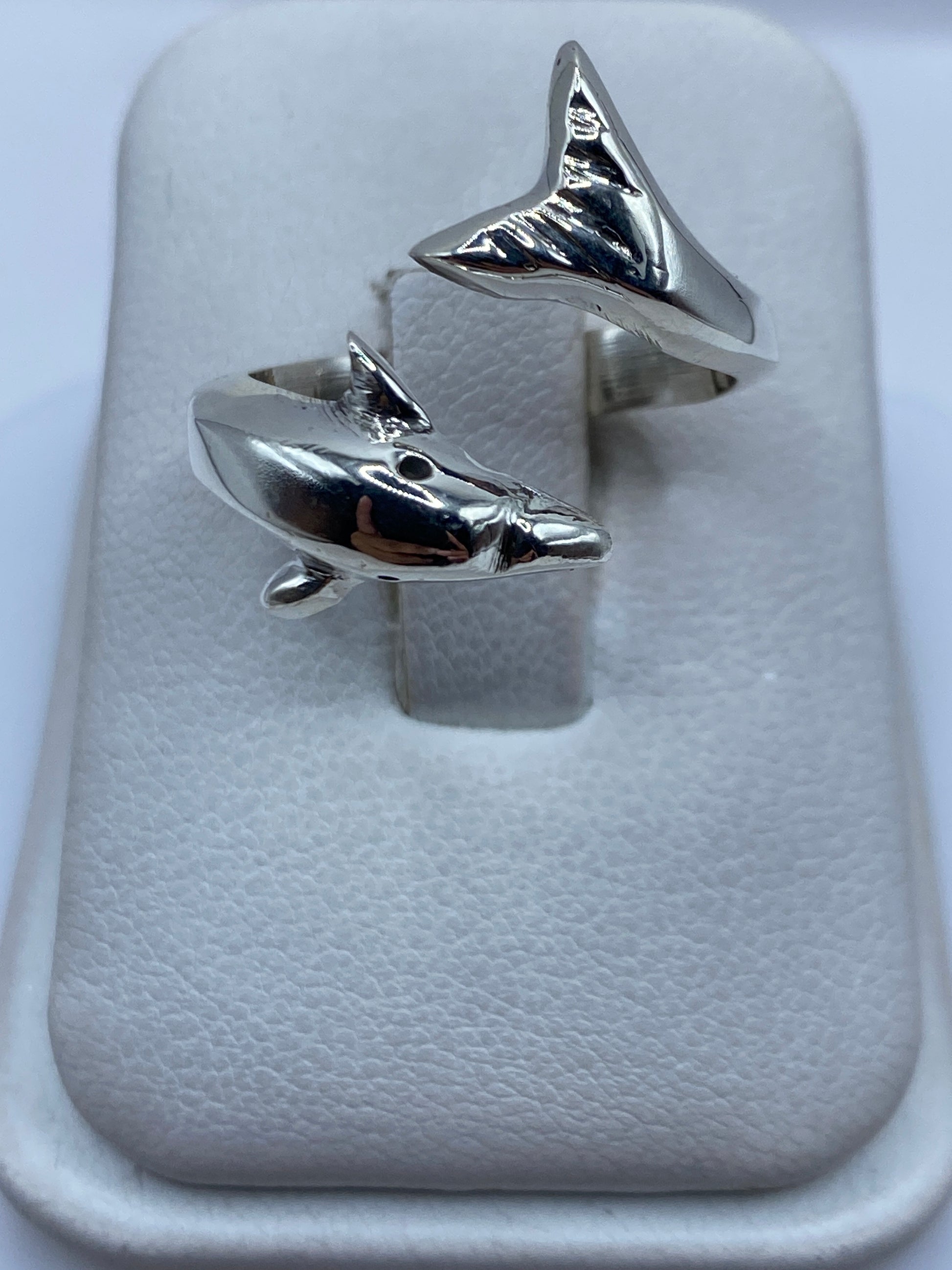 Anillo ajustable de plata con tiburones enfrentados, vista superior en estuche blanco