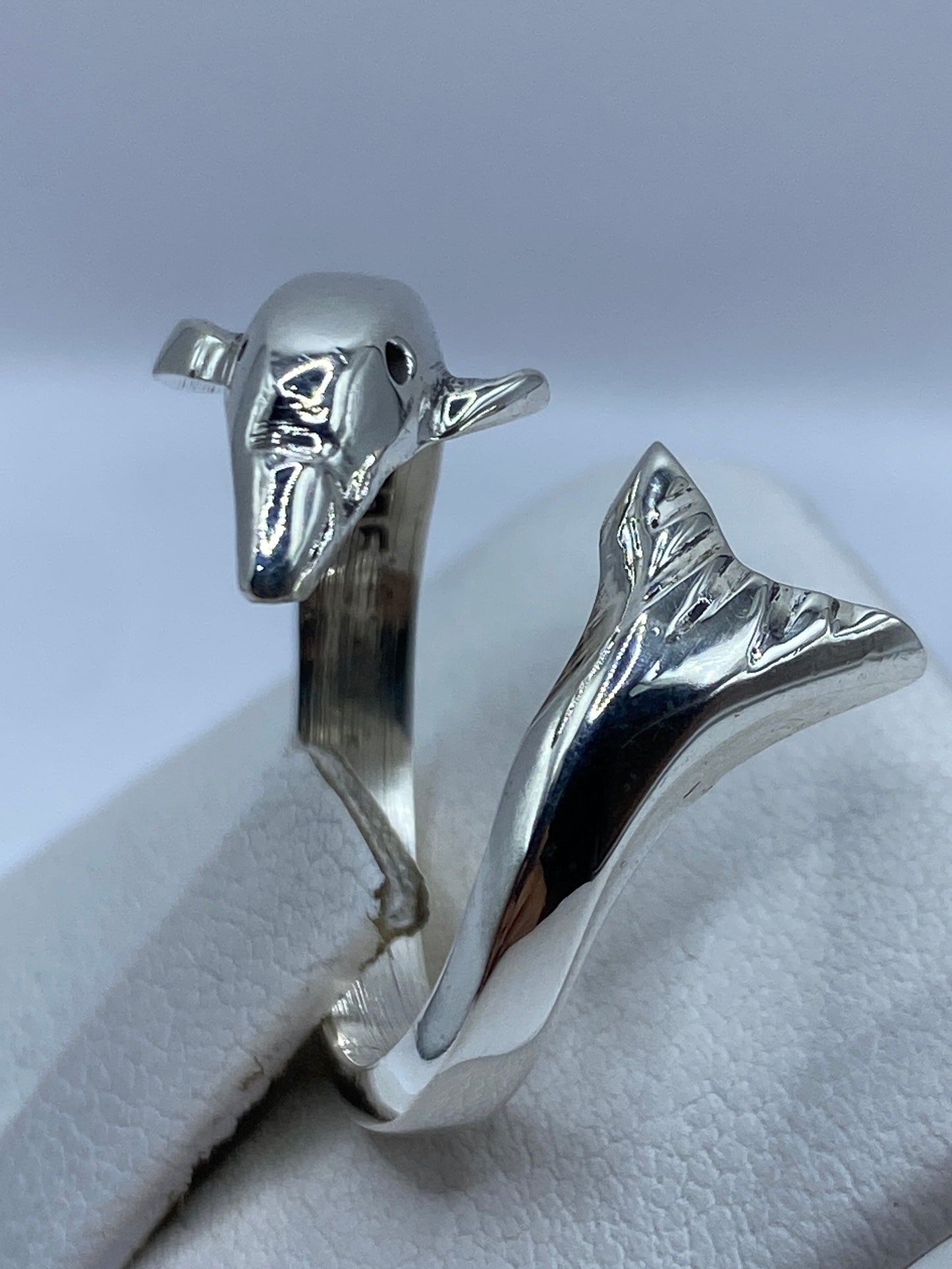Anillo ajustable en mano de mujer, tiburones enfrentados en perfecta armonía