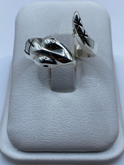 Anillo ajustable de plata .925 pulida con diseño escultural minimalista sobre soporte de exhibición