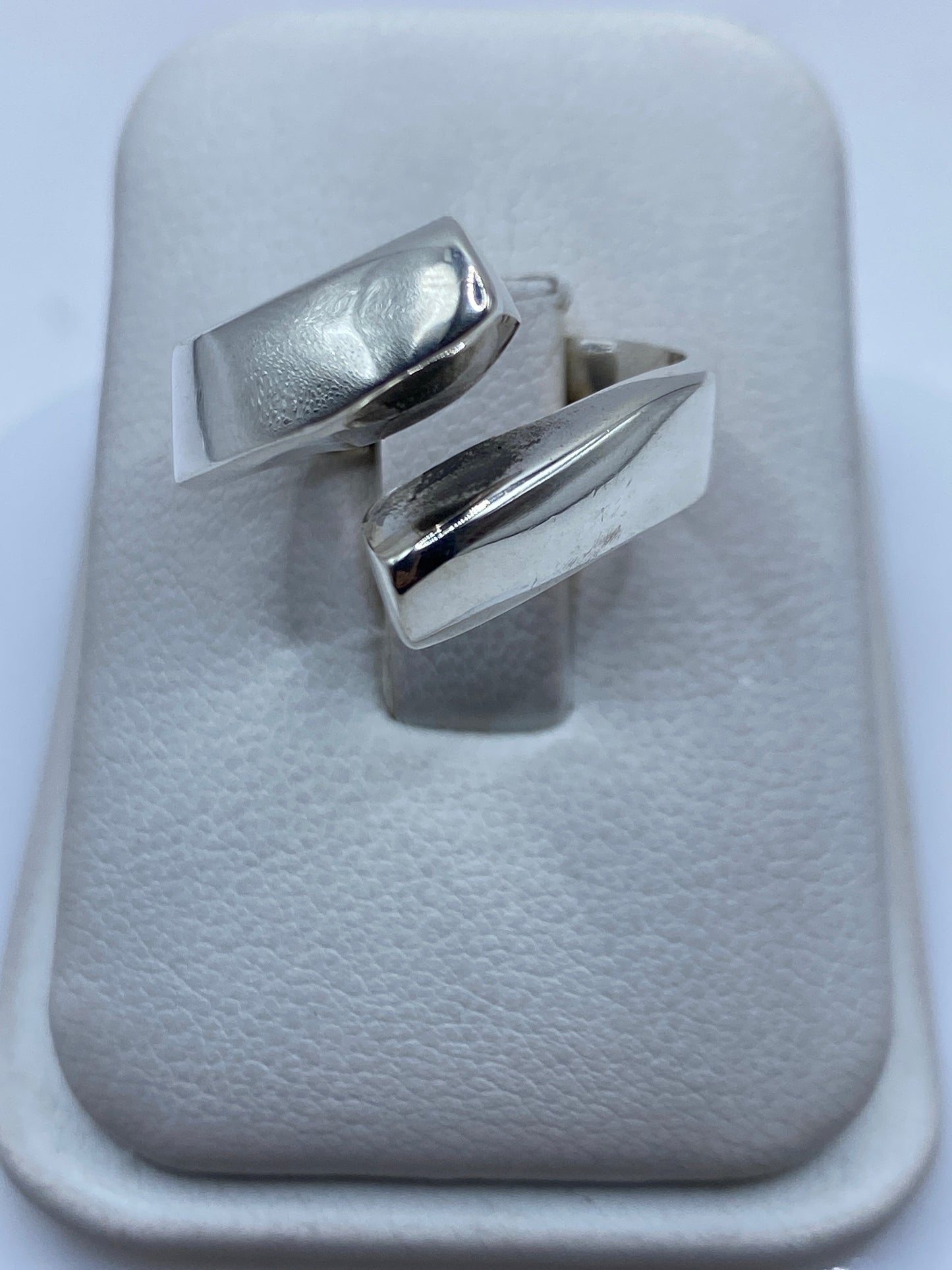 Anillo de plata ajustable con diseño geométrico moderno en presentación de tienda