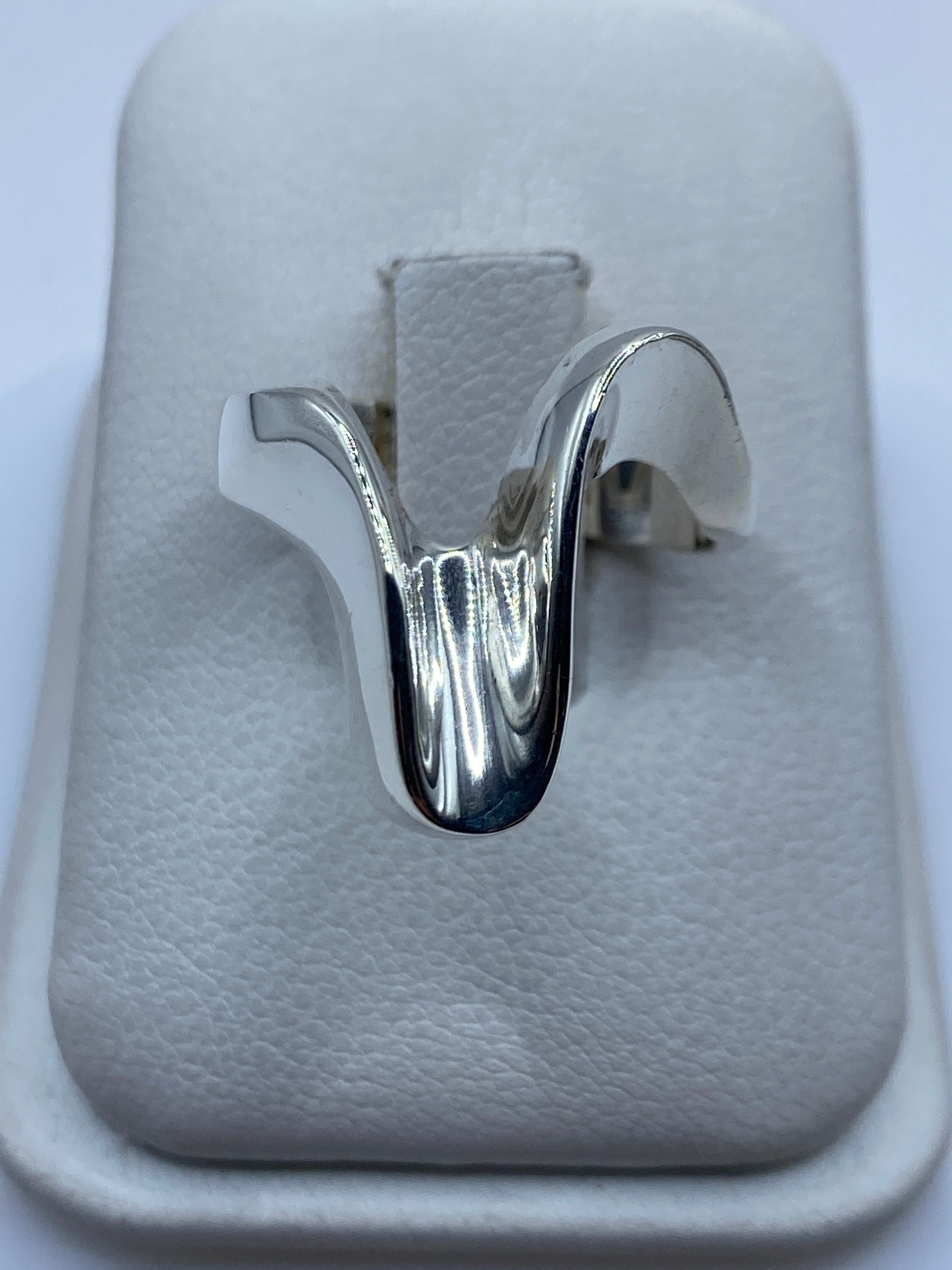 Anillo escultural de plata .925 en caja blanca, vista frontal del volumen orgánico