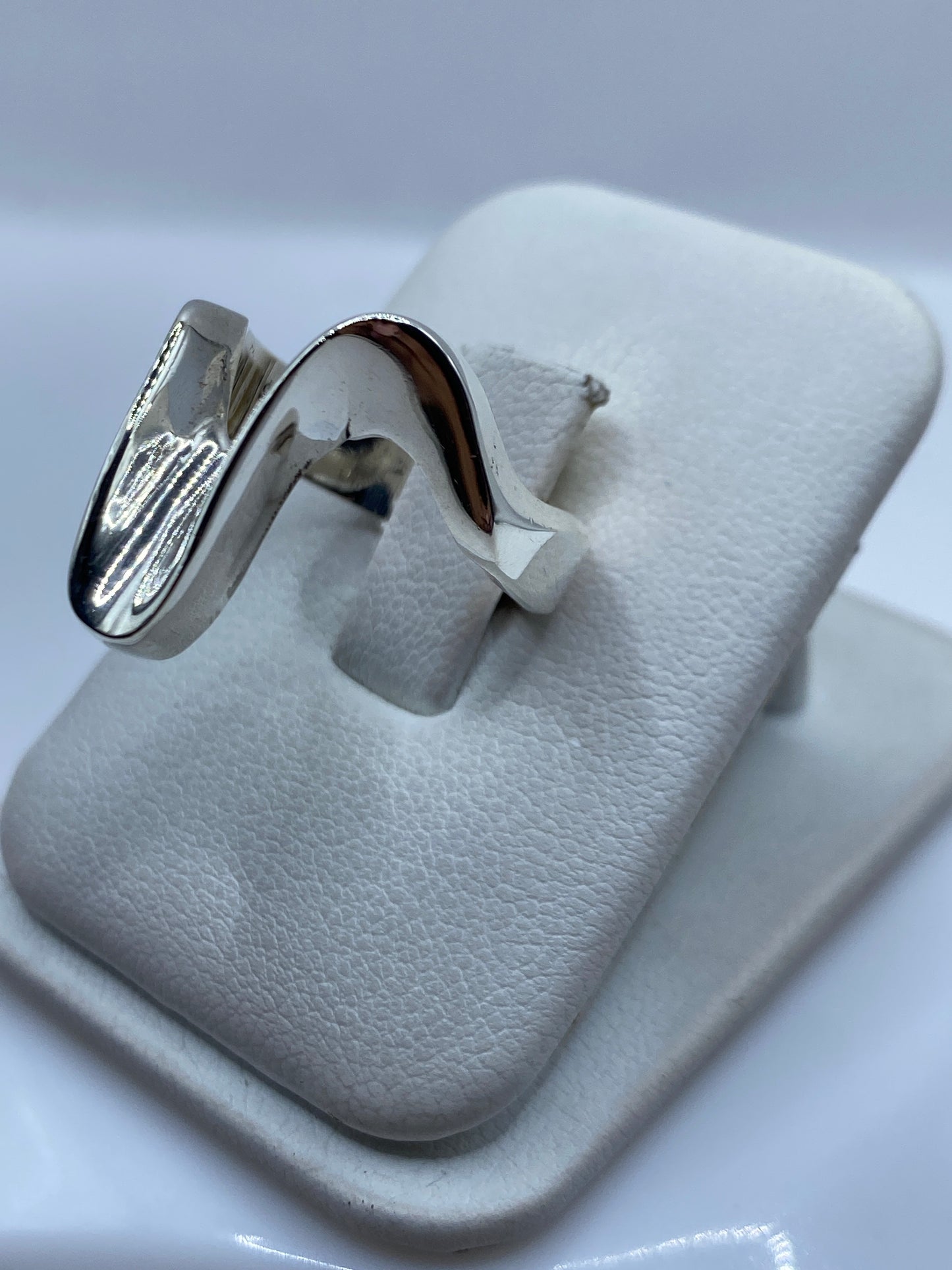 Anillo escultural en dedo, mostrando la forma tridimensional y pulido espejo