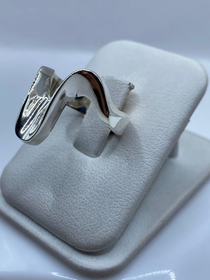 Anillo escultural en dedo, mostrando la forma tridimensional y pulido espejo