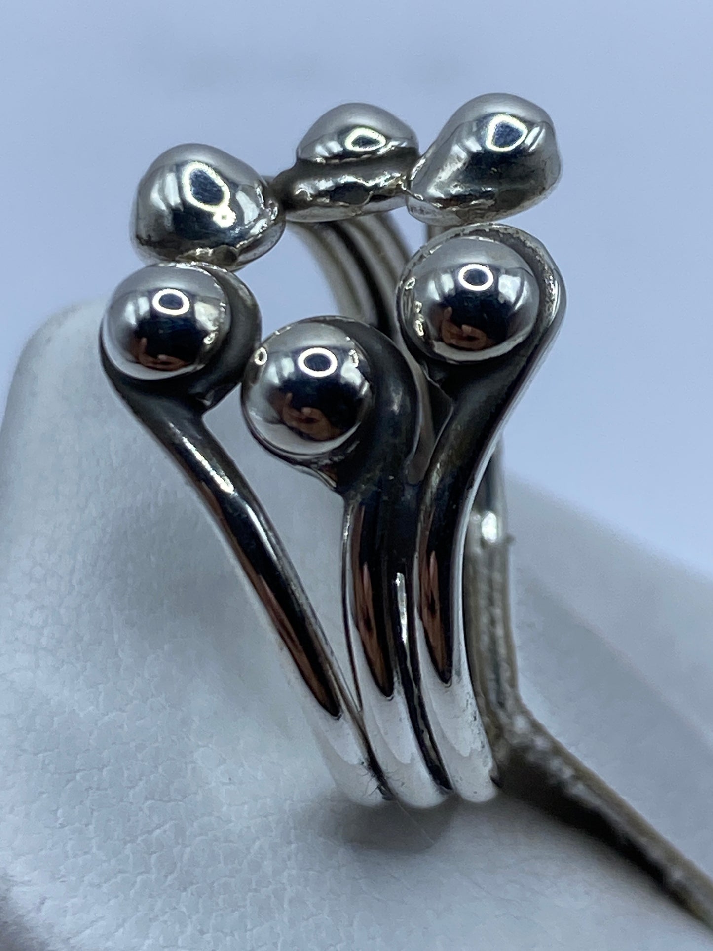 Anillo ajustable de plata en la mano, demostrando su versatilidad de talla