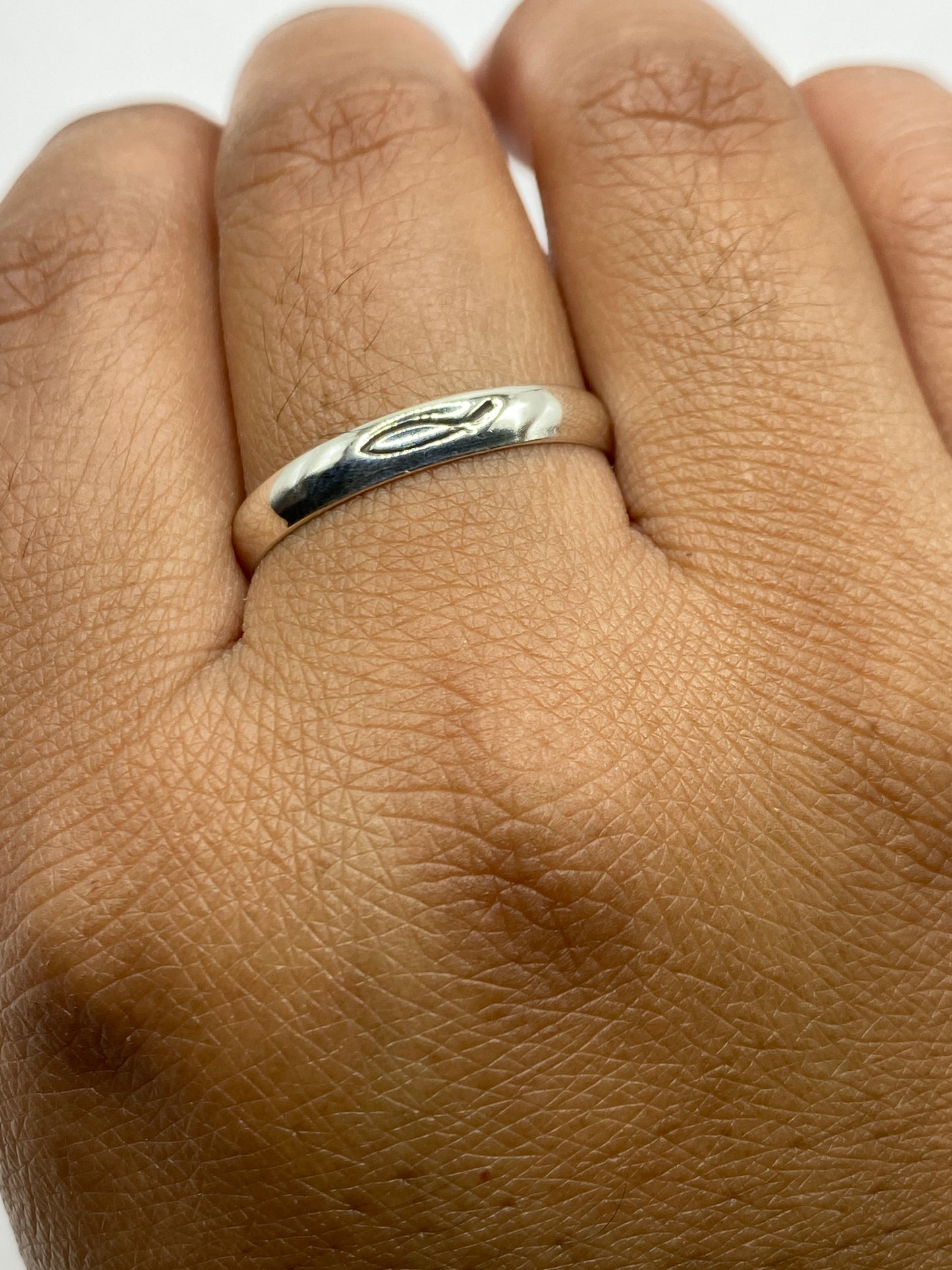 Anillo banda lisa sobre fondo blanco mostrando acabado espejo brillante