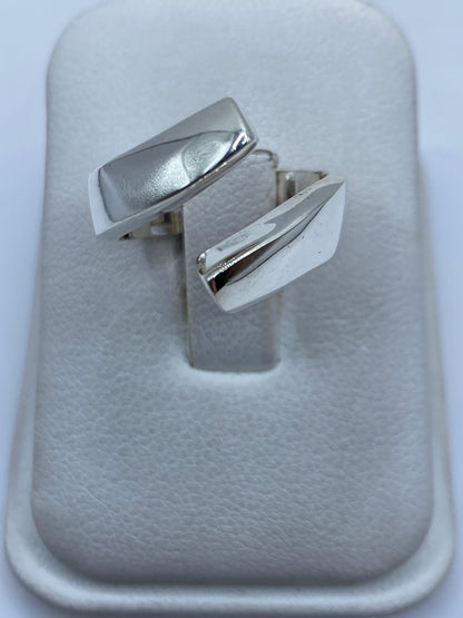 Anillo escultural de plata .925 con diseño geométrico minimalista en la mano de una mujer