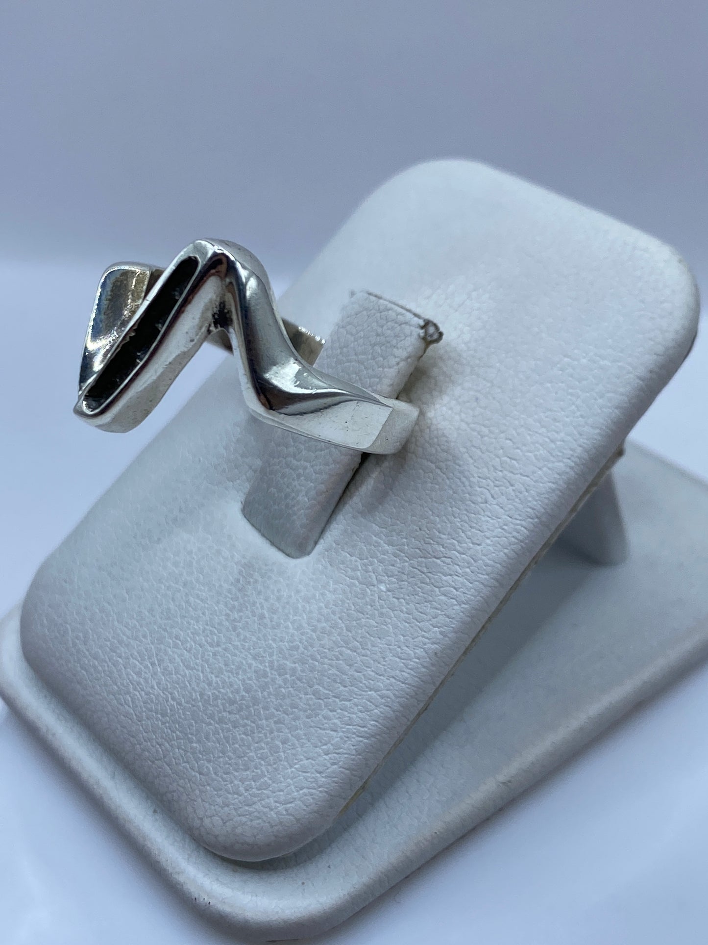 Detalle del anillo V en plata pulida mostrando el acabado de alto brillo