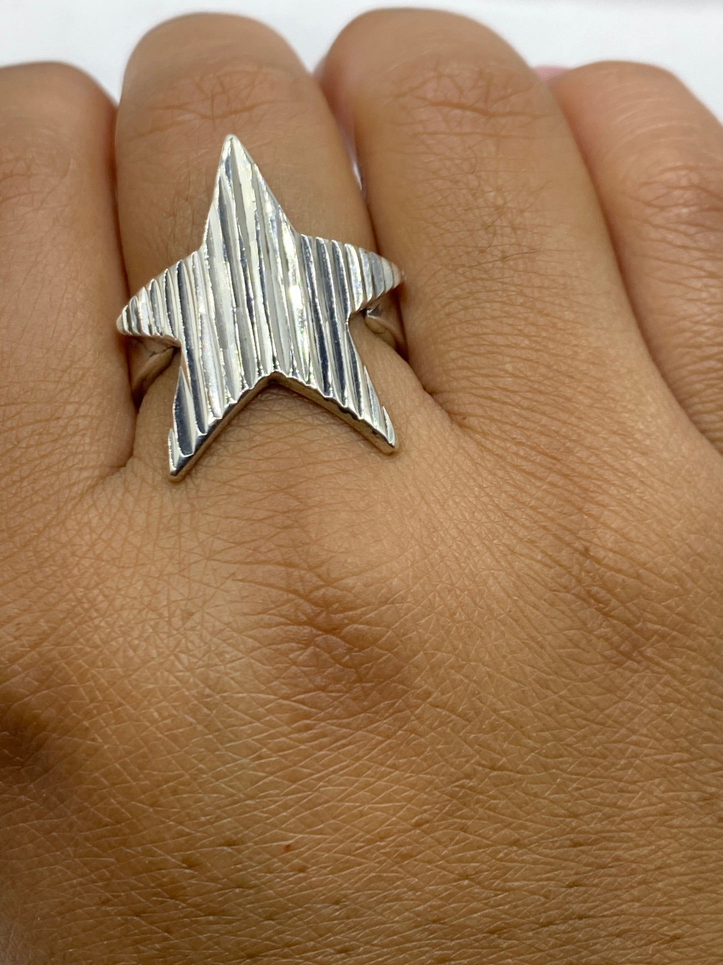 Anillo estrella sobre fondo blanco mostrando sello 925 MEXICO en la banda