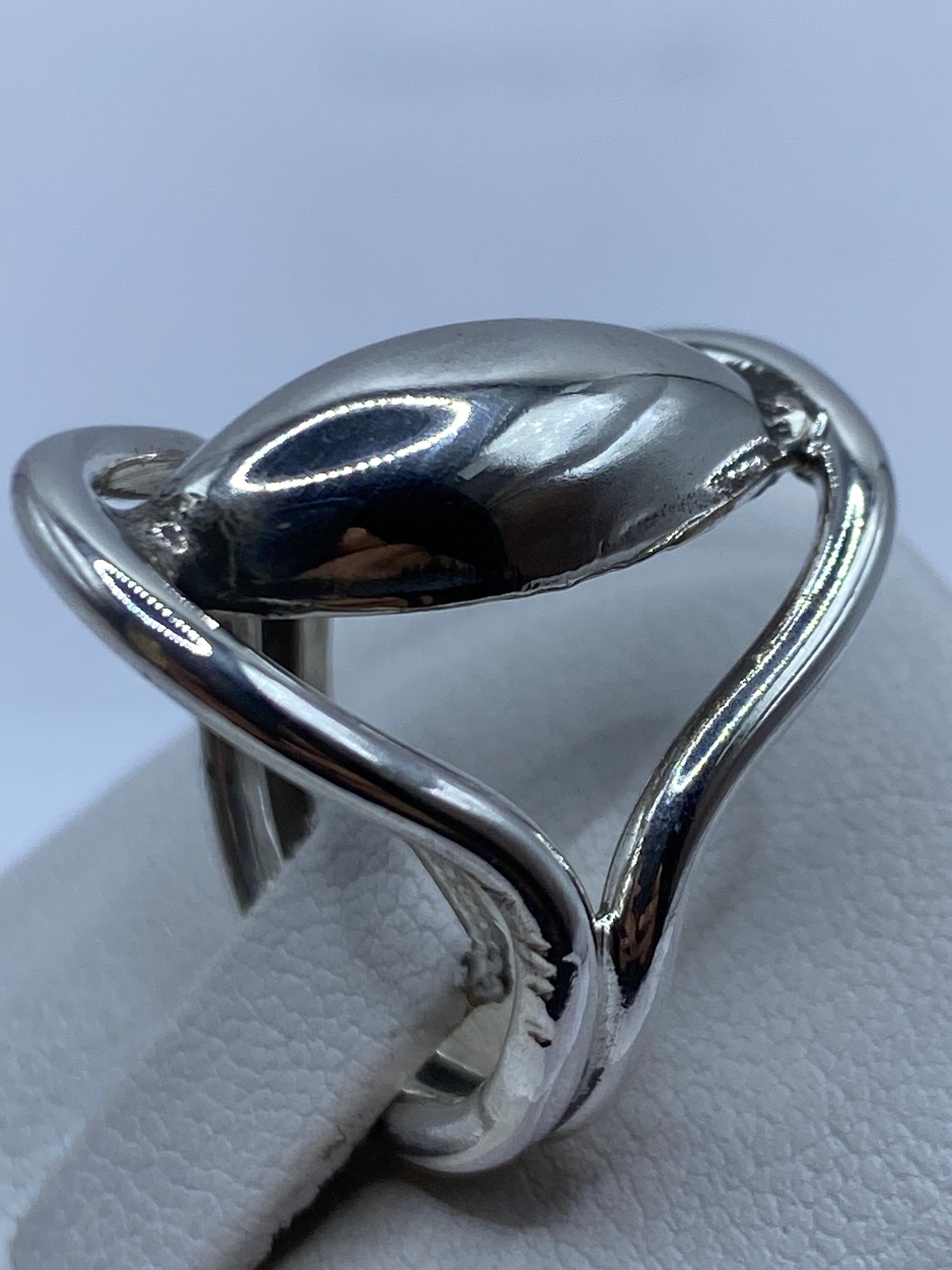 Detalle lateral del anillo minimalista en plata pura, relieve sutil