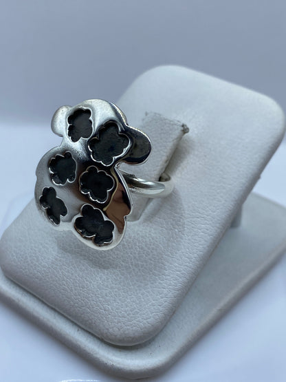Anillo floral ajustable en mano de mujer, mostrando los detalles tallados de cada flor