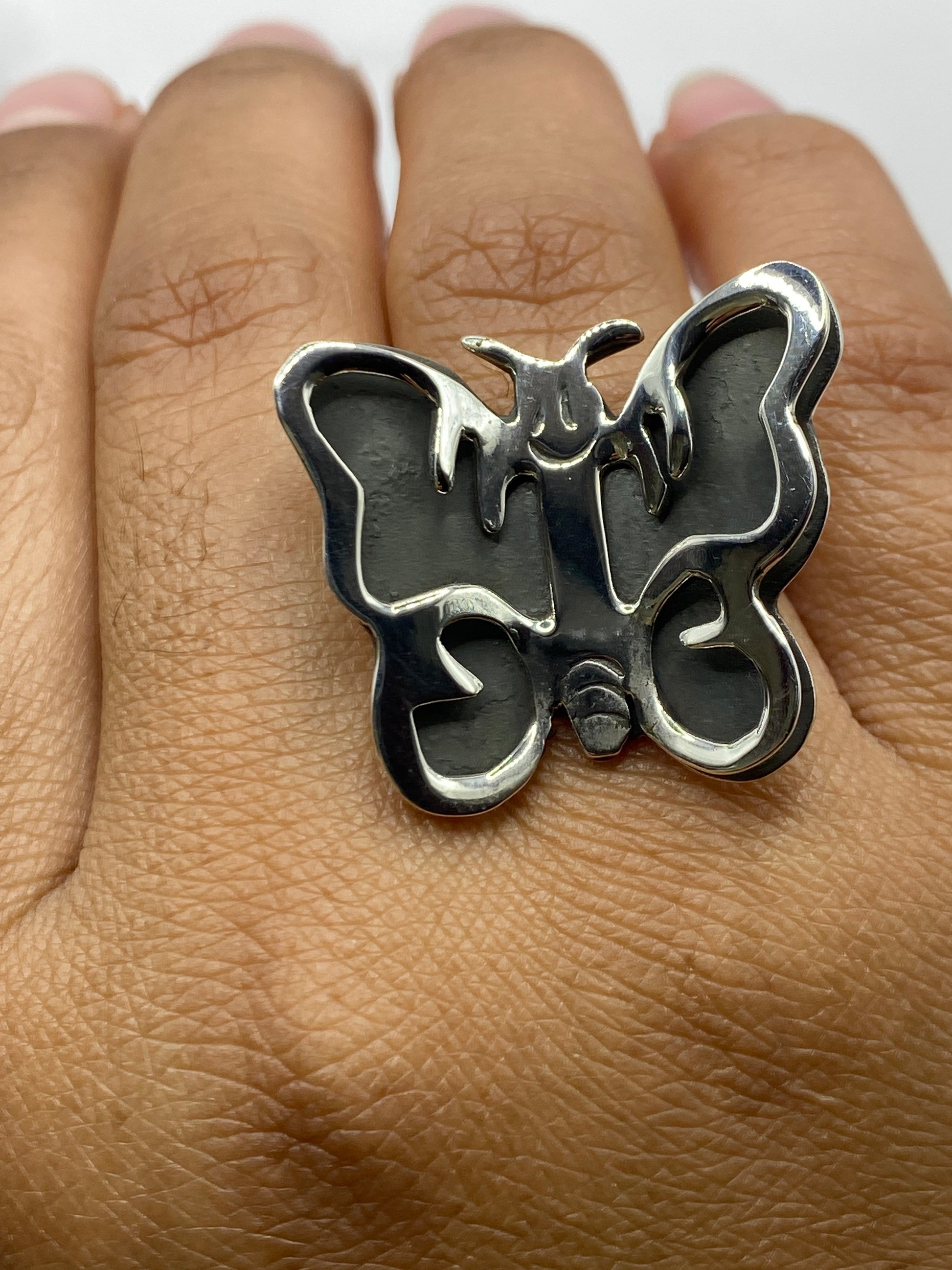 Anillo mariposa sobre superficie neutra mostrando el acabado pulido en plata
