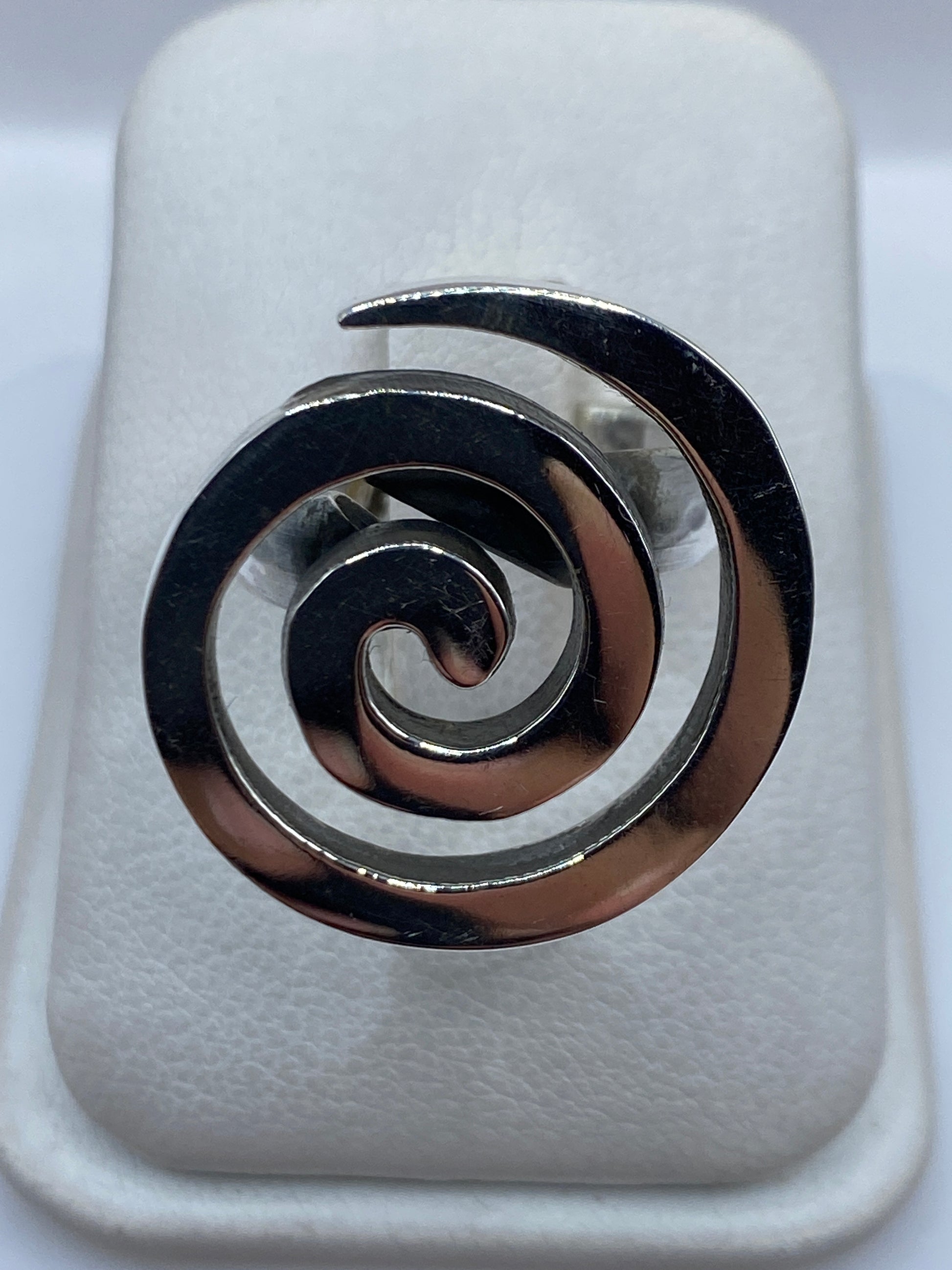 Anillo giratorio de plata con espiral doble en la mano de una mujer
