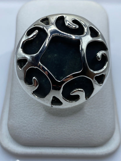 Anillo de plata calado con diseño geométrico étnico en la mano de una mujer