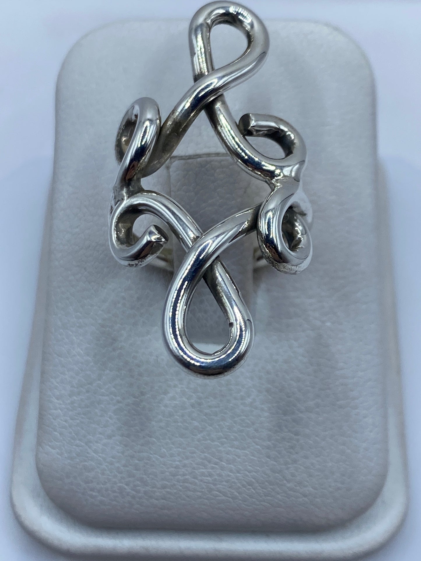 Anillo de plata en calado con diseño geométrico abierto, vista frontal en dedo
