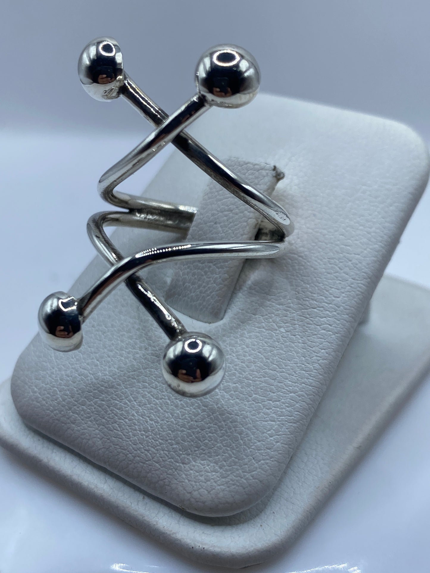 Anillo ajustable en la mano, mostrando la estructura geométrica de eslabones