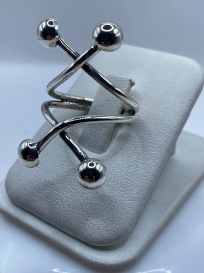 Anillo ajustable en la mano, mostrando la estructura geométrica de eslabones