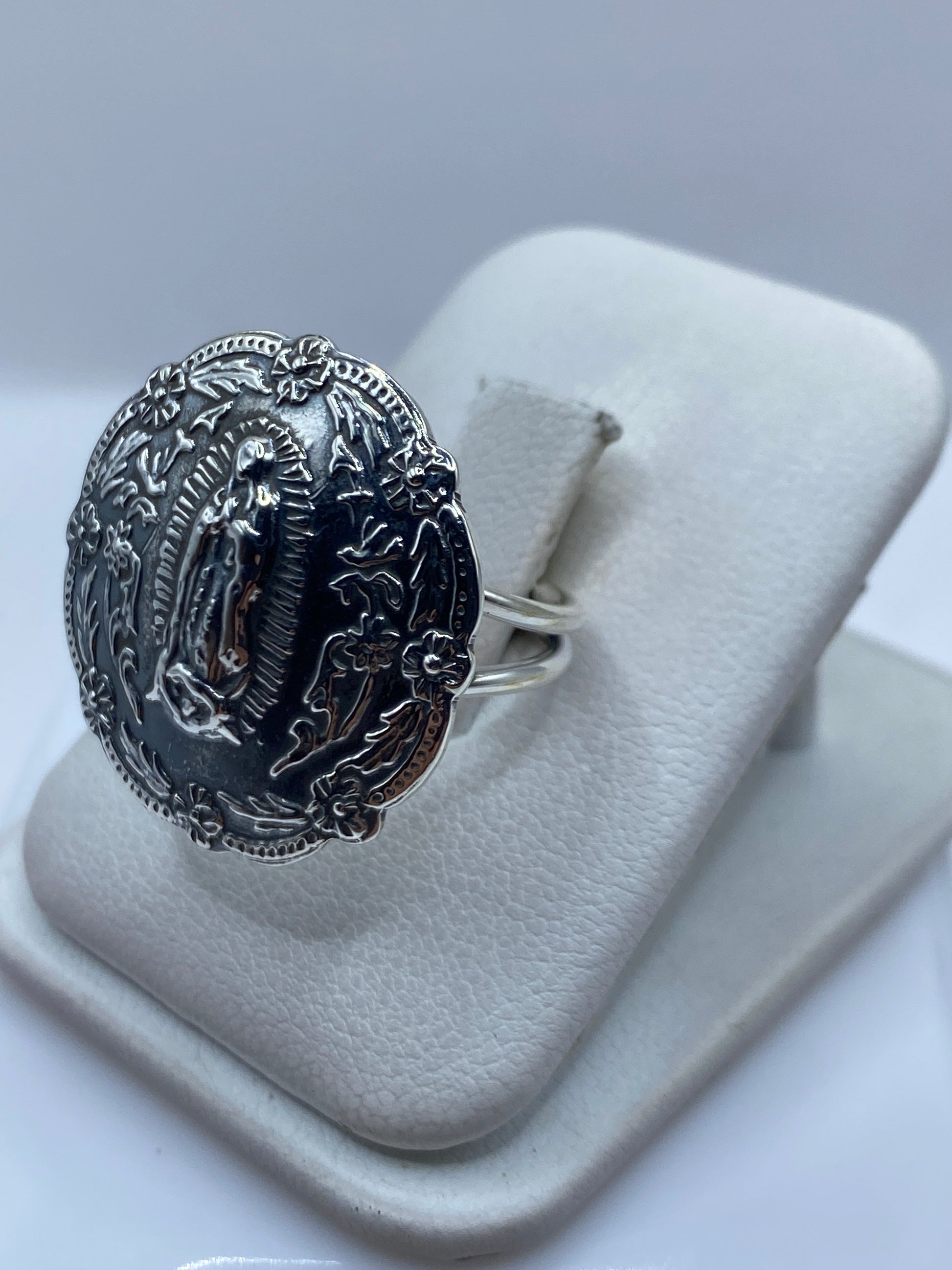 Detalle del rostro sereno de la Virgen y la aureola radiante grabada en plata