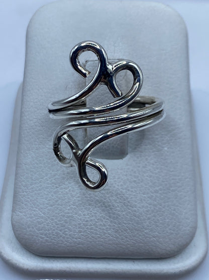Anillo de plata calado minimalista visto desde arriba sobre estuche blanco