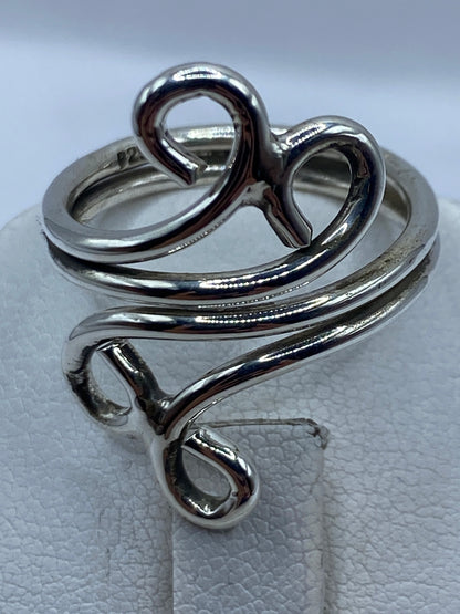 Anillo de plata calado en dedo con luz natural destacando los vacíos