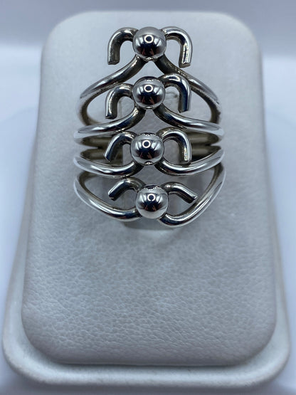 Anillo de plata en calado con motivos geométricos escultóricos en la mano de una mujer