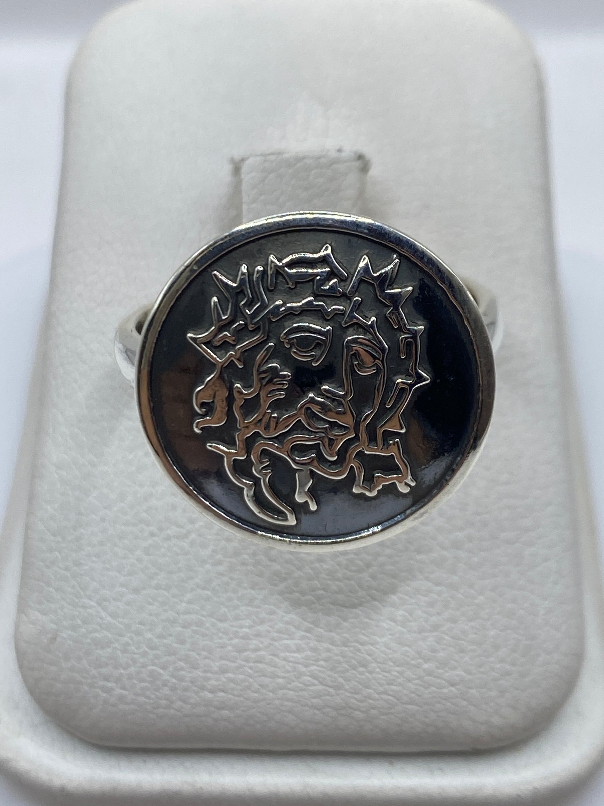 Anillo de sello en plata .925 sobre fondo blanco mostrando el relieve del rostro
