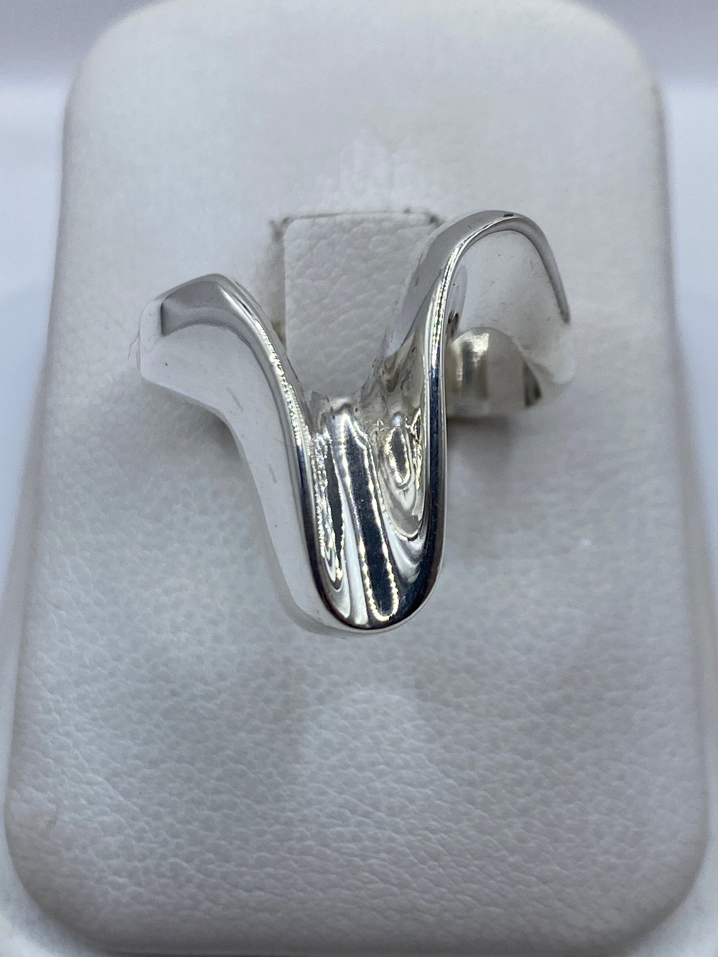 Anillo de plata cartoneado con volumen 3D sobre tela blanca