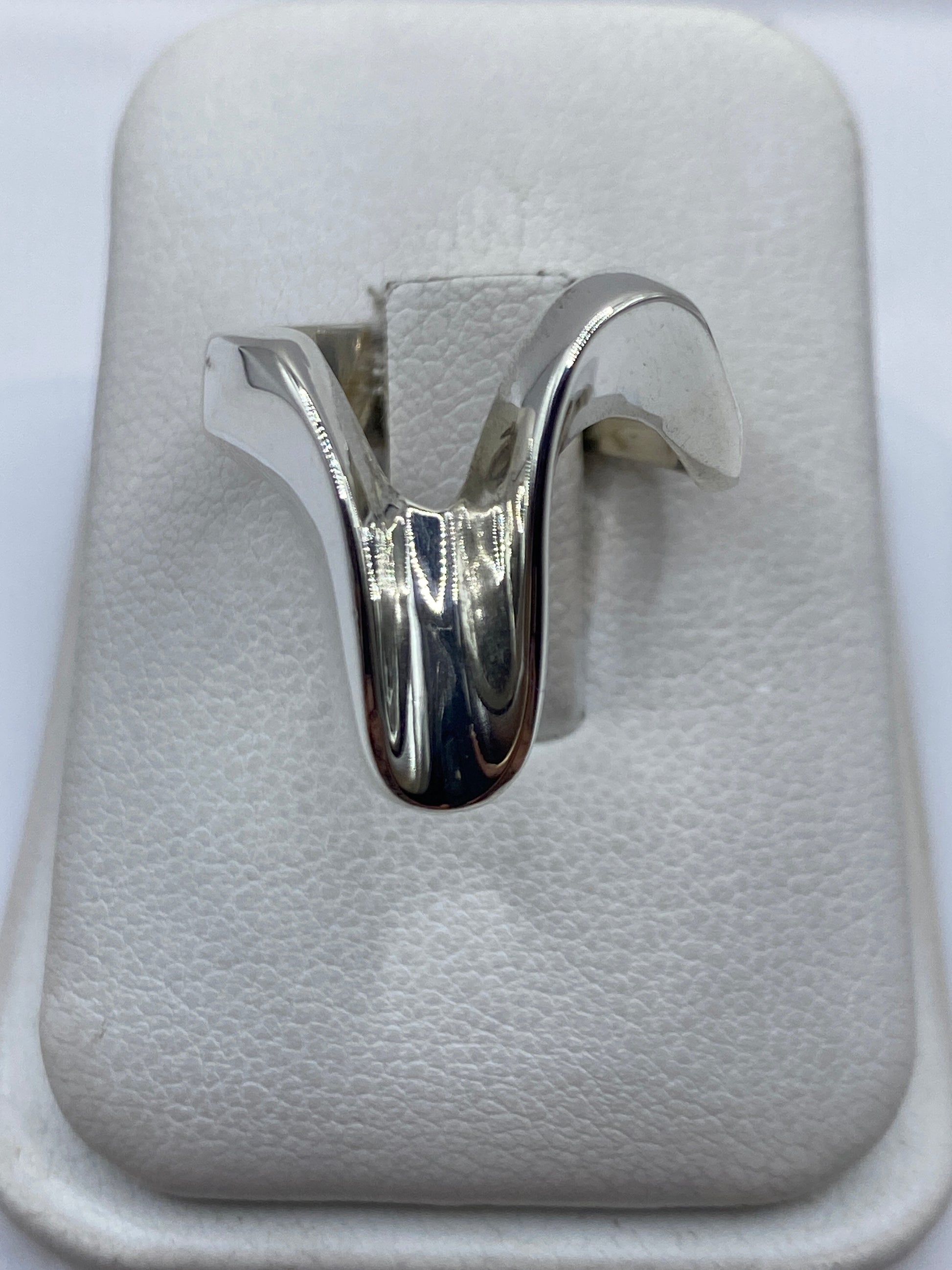 Anillo de plata cartoneado con volumen 3D sobre algodón blanco