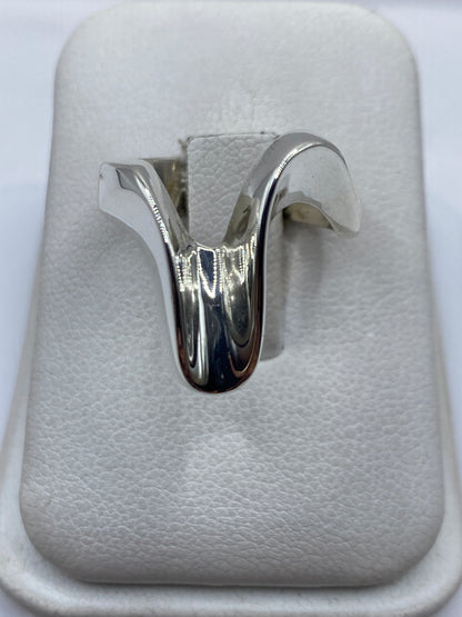 Anillo de plata cartoneado con volumen 3D sobre algodón blanco