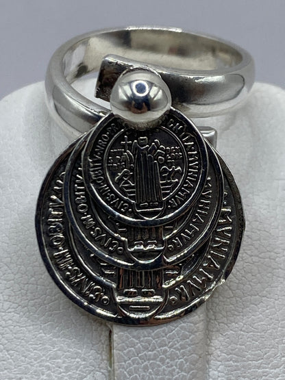 Anillo ajustable de plata en dedo de mujer, luciendo el diseño religioso con elegancia y devoción