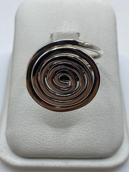 Anillo de plata calado con espiral geométrica en dedo de mujer