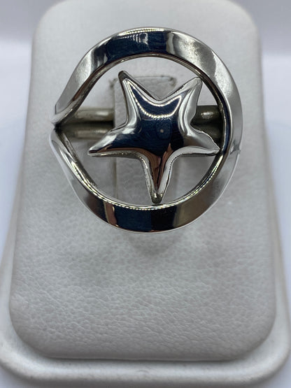 Anillo de plata calado con estrella abierta en el dedo, vista frontal
