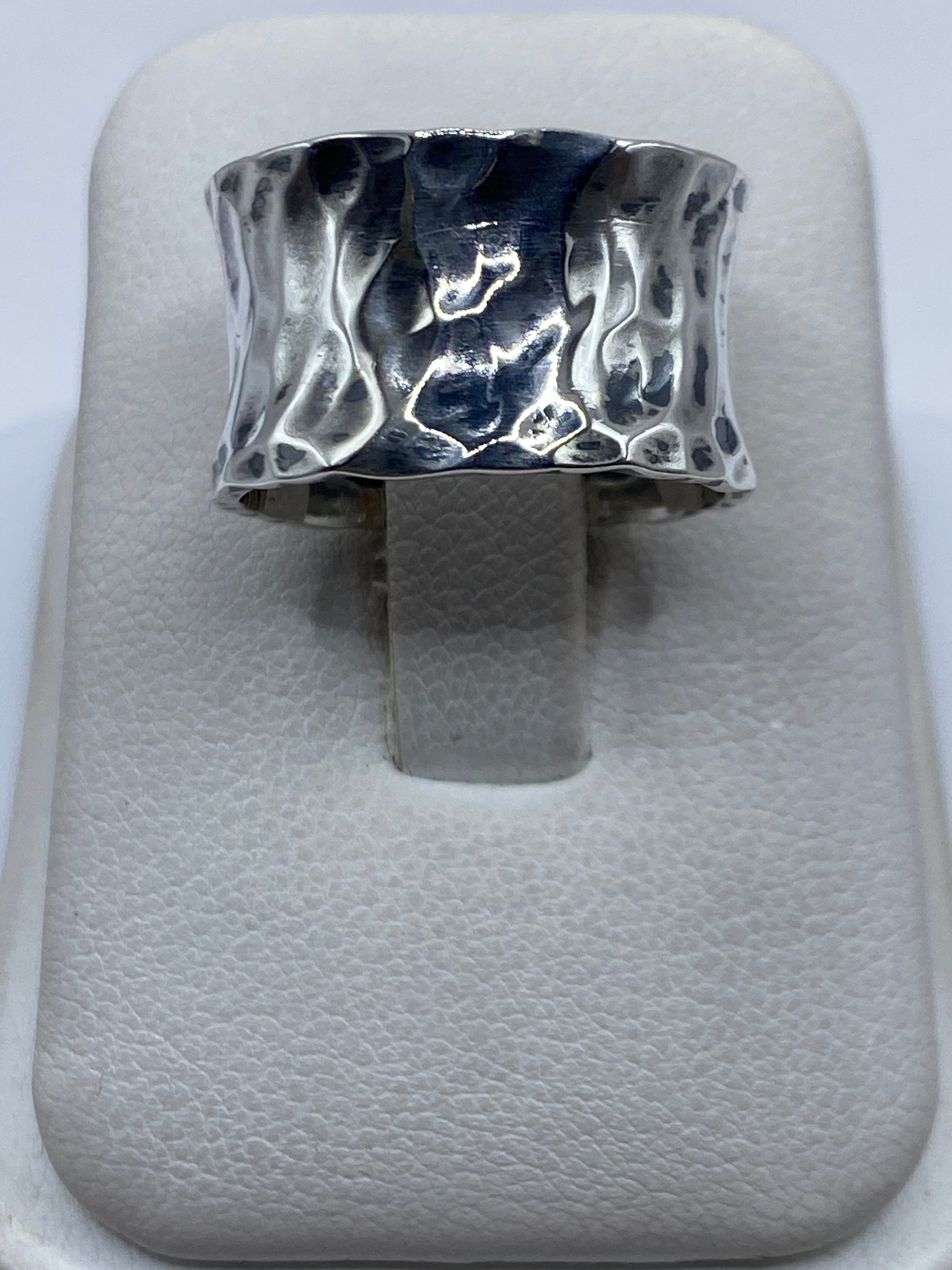 Anillo de plata repujado con textura martillada en vista superior sobre fondo blanco
