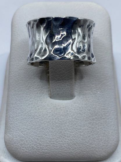 Anillo de plata repujado con textura martillada en vista superior sobre fondo blanco