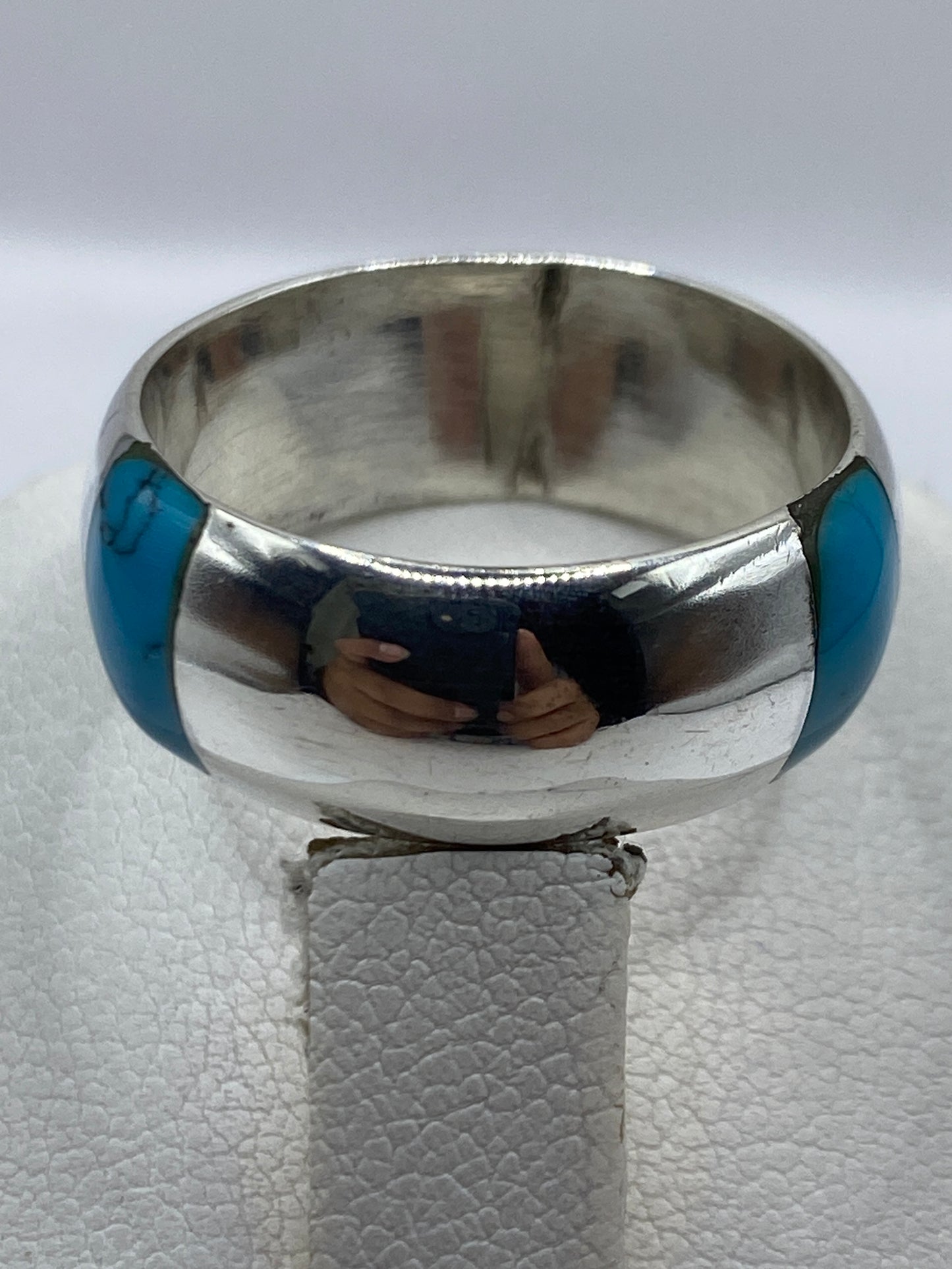 Detalle del anillo en la mano, turquesa azul cielo brillando contra la piel