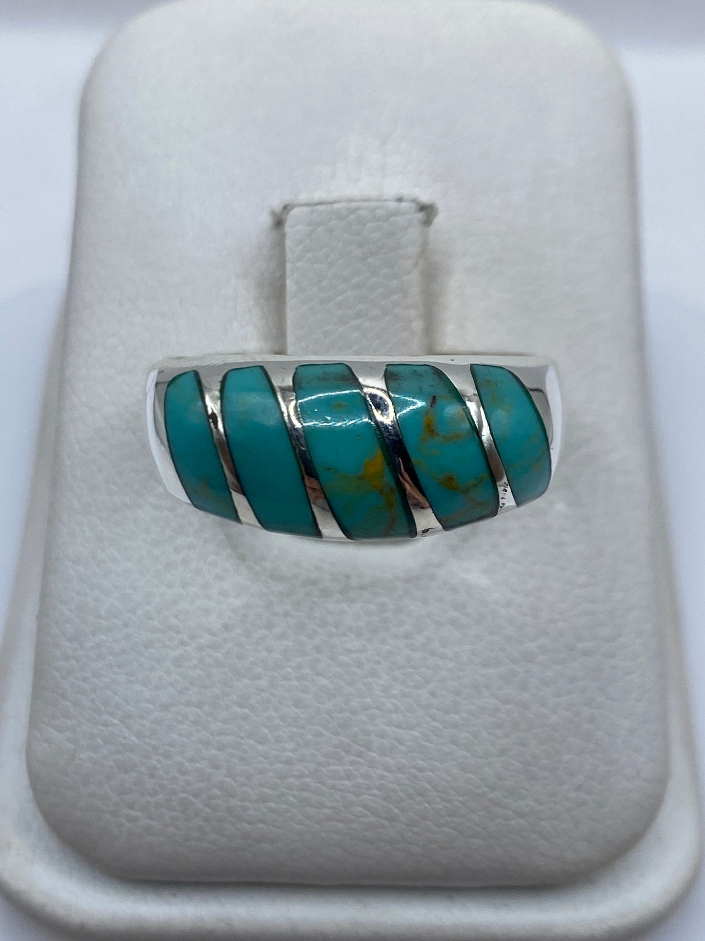Anillo de plata .925 con turquesa azul cielo engastada en cinco piezas, visto de frente en presentador blanco