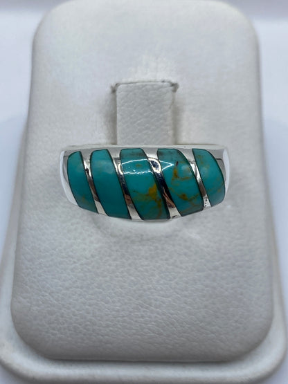 Anillo de plata .925 con turquesa azul cielo engastada en cinco piezas, visto de frente en presentador blanco