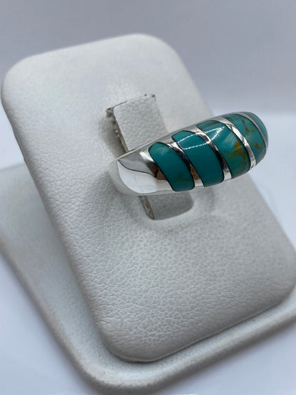 Detalle lateral del anillo unisex mostrando el engaste individual de cada turquesa en plata