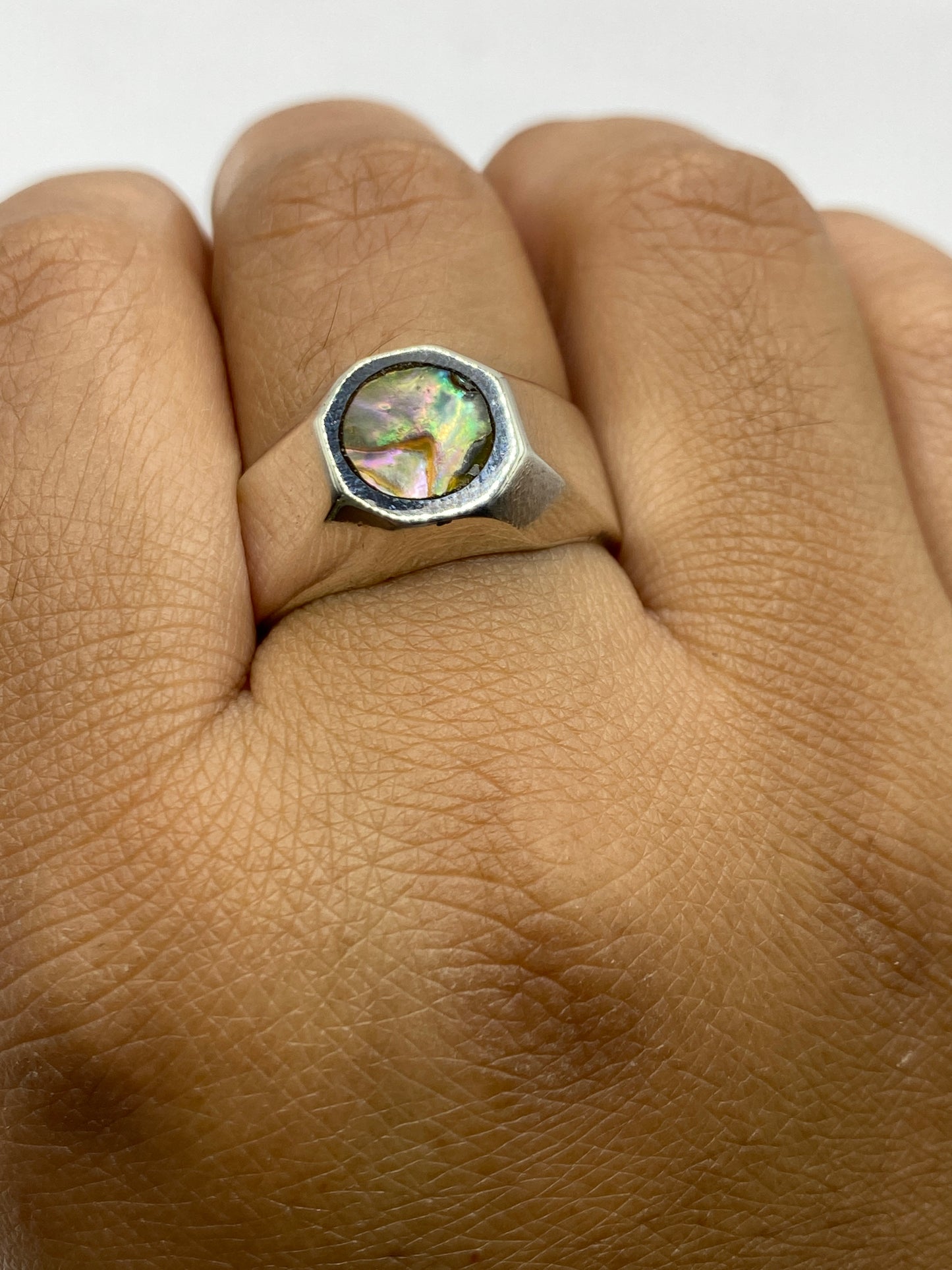 Anillo sobre fondo gris mostrando el contraste de la plata pulida y la piedra