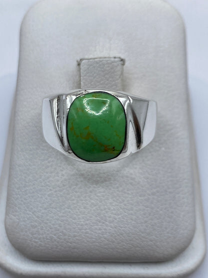 Anillo de plata sello con piedra verde engastada en la mano de una mujer