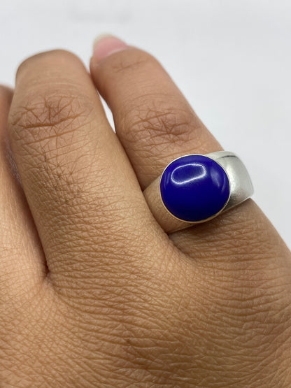 Anillo sobre superficie reflectante, piedra azul intenso en primer plano