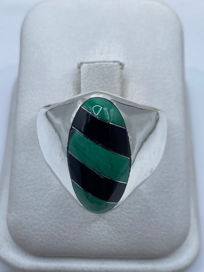 Anillo de plata .925 con malaquita verde engastada, talla 11, sobre almohada blanca