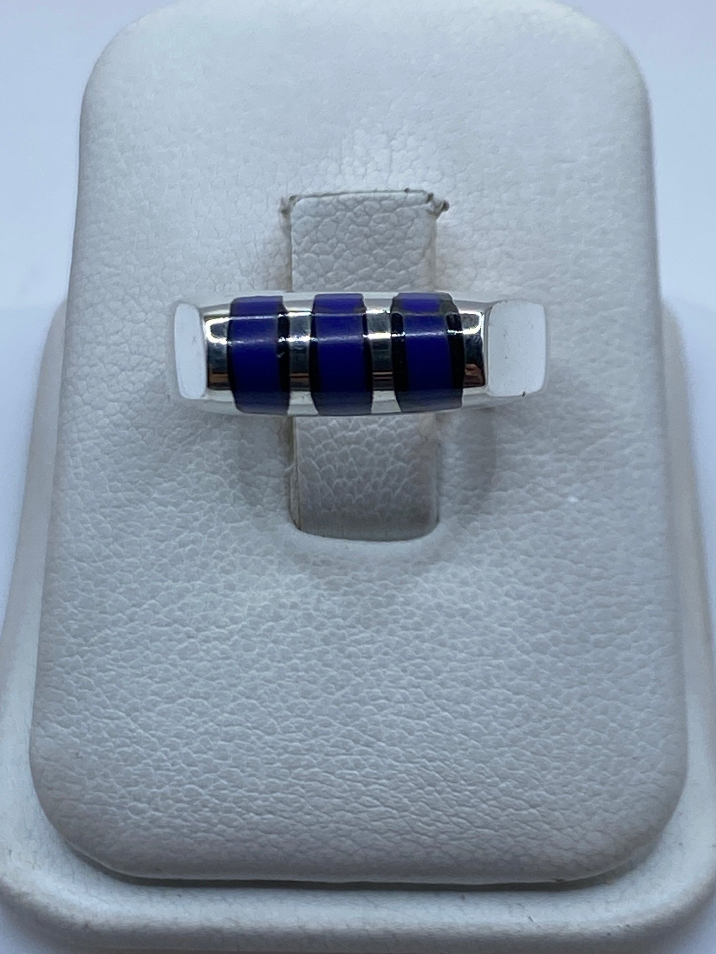 Anillo de plata .925 con tres bandas de piedra azul sobre cojín blanco