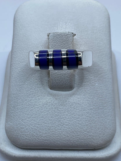 Anillo de plata .925 con tres bandas de piedra azul sobre cojín blanco