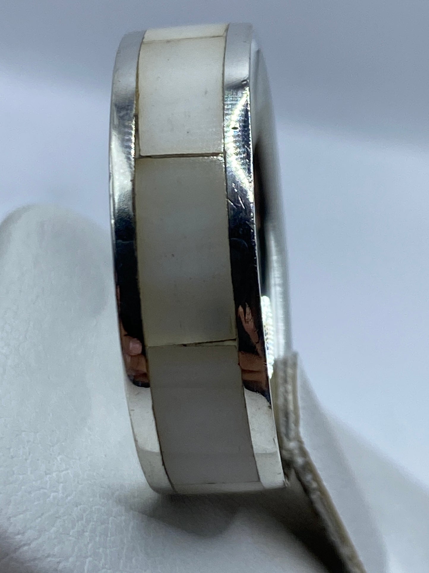 Anillo sobre dedo mostrando la elegancia de la perla sobre plata brillante