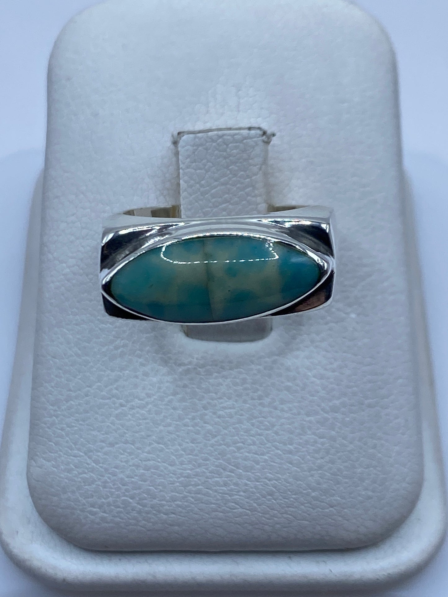 Anillo de plata con piedra azul cielo engastada a mano, vista frontal en estuche blanco