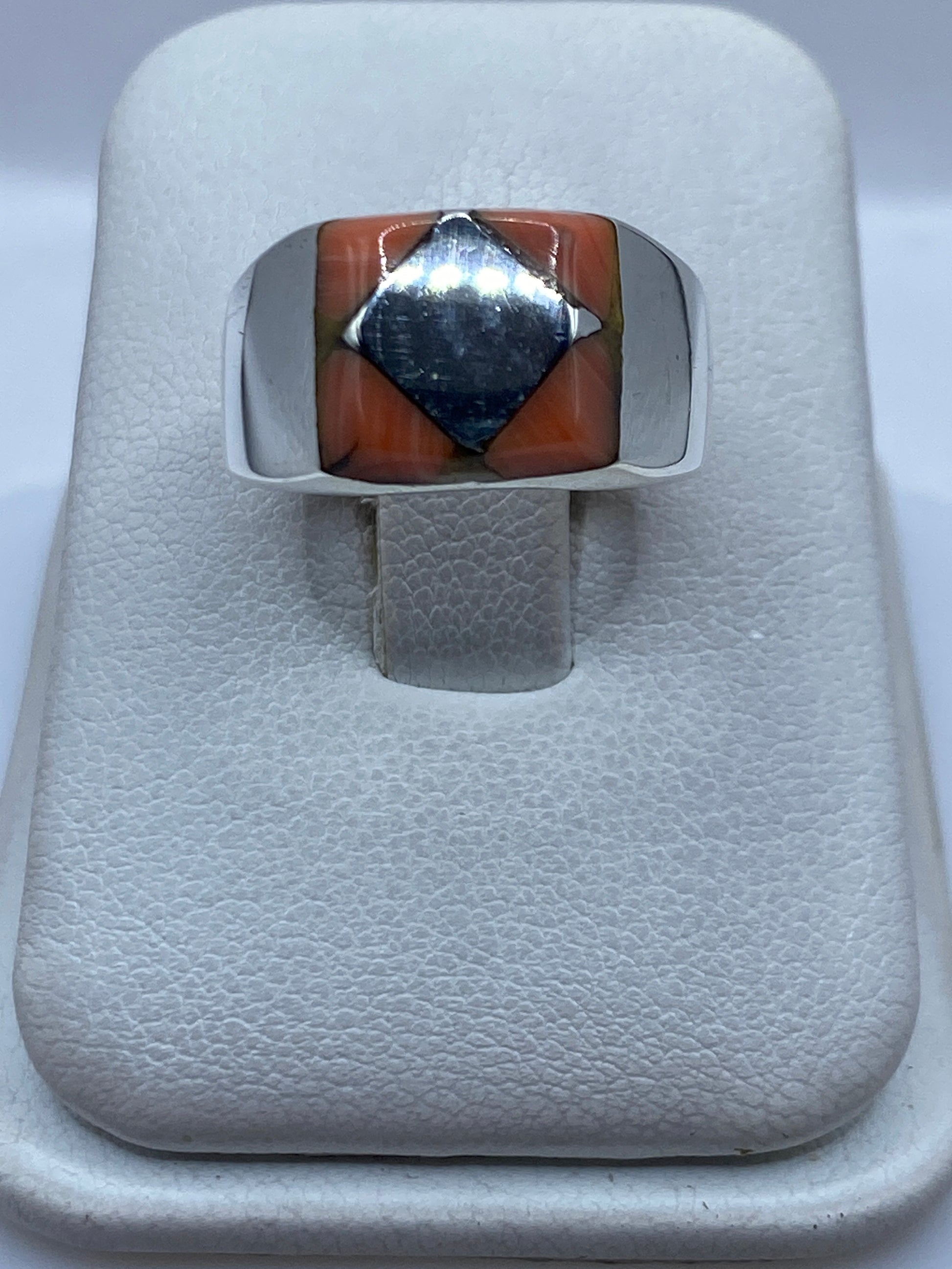 Anillo de plata .925 con piedra engastada a mano, vista frontal sobre joyero blanco