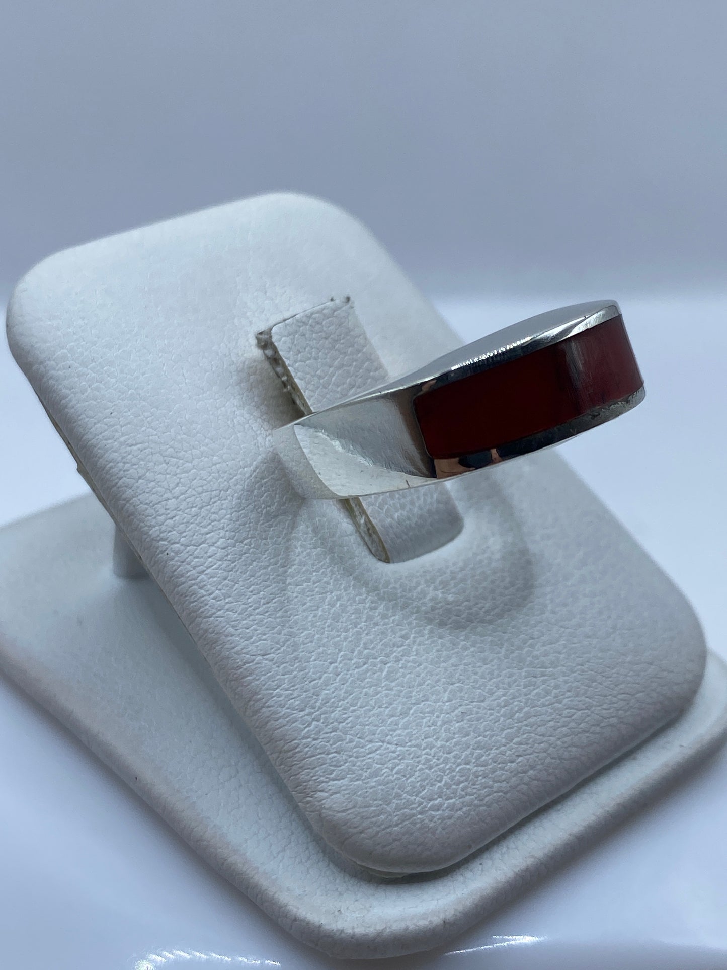 Vista frontal del anillo con coral rojo brillante y marco de plata pulida