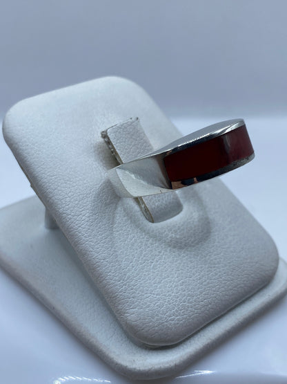 Vista frontal del anillo con coral rojo brillante y marco de plata pulida